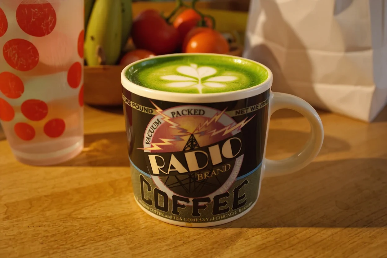 Kitchen mug photo edited with Flux Kontext Pro to show a matcha latte with leaf latte art in morning sunlight